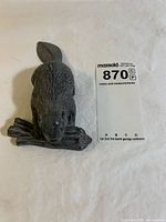 Top view of dark gray resin beaver figurine on log with scale card