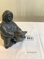 Front view of bronze child holding dog