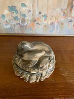 lid on showing sculpted birds and marbled finish