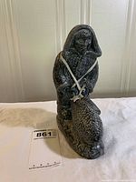 Front view of soapstone Inuit figurine with fish and height tag visible