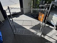 Front view of chrome wire shelving unit showing three shelves