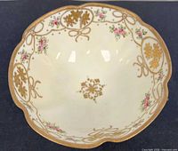 Interior view showing scalloped rim, gilt floral and ribbon decoration, central medallion