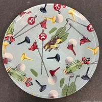 Front view of round plate displaying golf motif fabric under glass