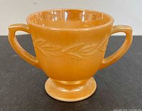Front view of peach lustre sugar bowl showing laurel leaf pattern and double handles