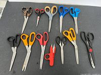 All twelve scissors arranged on black surface