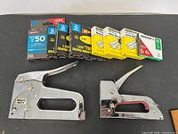 Two staple guns with six boxes of staples