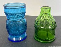 Blue juice glass and green bottle front view