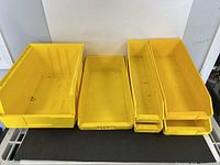 Front view showing five of the yellow AkroBins in assorted sizes