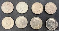 Obverse of eight Kennedy half dollars showing varying wear