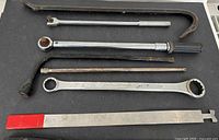 Overall view showing eight large hand tools laid out on surface