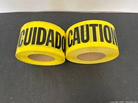 Front view showing both full rolls, clearly displaying "CUIDADO" and "CAUTION" text