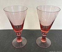 Two pink bubble glass goblets front view