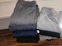 Stacked sweatpants showing variety of greys, navy and black