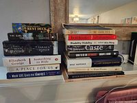 Two stacks of books and Rest Deck on shelf