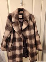 Front view of plaid coat showing pattern, buttons, lapel and lining