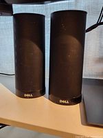 Pair of Dell black cylindrical speakers side by side