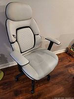 Front angled view of chair showing upholstery, armrests, seat and base