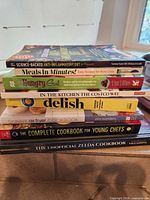 Stack of all eight cookbooks showing spines