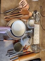 All items laid out showing pans, utensils, measuring sets, baskets, press, straws