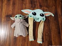 Grogu plush doll beside matching ear-moving hat