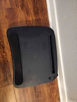 Top view of black lap desk showing wrist rest and device slot