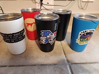 Front view of five colored Miir tumblers showing graphics and lids