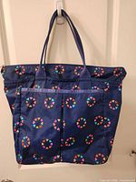 Front view of navy tote showing heart pattern and exterior pockets