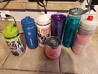 All seven drinks containers lined up showing fronts