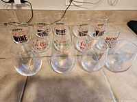 Group of 13 stemless wine glasses showing iridescent and printed designs