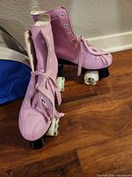 Pair of pink quad roller skates left side view