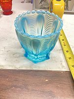Front view showing blue opalescent vase, scalloped rim and swirl panels