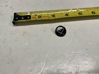 Pin beside tape measure showing size and design