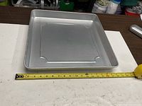 Top view of aluminum pan with tape measure showing dimensions