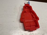 Top view of red silicone LEGO minifigure cake mold with hang tag