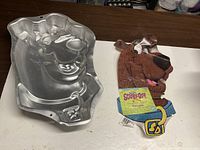 Aluminum Scooby-Doo cake pan and paper insert displayed on table