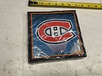 Front view of sealed pack showing Canadiens logo and size reference with tape measure
