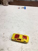 Angled top view of yellow die-cast car with red interior