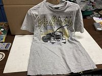 Front of grey Def Leppard T-shirt showing logo and truck graphic