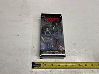 Front of sealed Dungeons & Dragons 3-pack showing figures and measuring tape indicating ~7 in height