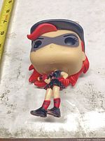 Front view Funko Pop! Batgirl vinyl figure beside tape measure