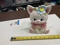 Front view of ceramic kitten planter with measuring tape