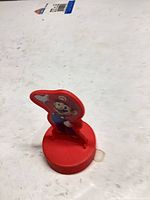 Front view of Mario figurine on red cylindrical base