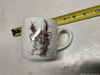 Front view of mug with llama illustration next to tape measure showing dimensions