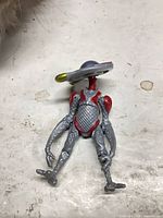 front view of silver grey and red alien robot figure