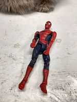 Front view of Spider-Man action figure showing red and blue suit and wear