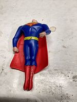 Front view of Superman action figure showing missing/loose head, paint wear