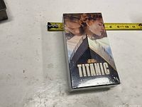 Front view of sealed Titanic DVD package with measuring tape for scale