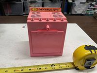 Front view showing burners, knob, logo strip, measuring tape for scale
