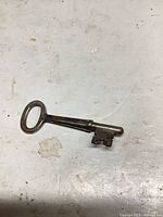 Full view of the steel skeleton key showing bow, shaft and bit with patina