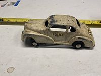 Left side view of cream diecast police car with POLICE decal